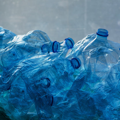 &lt;Pile of damaged blue plastic bottles  lying on the concrete floor returned for recycling. Credit&gt; AdobeStock_223169122