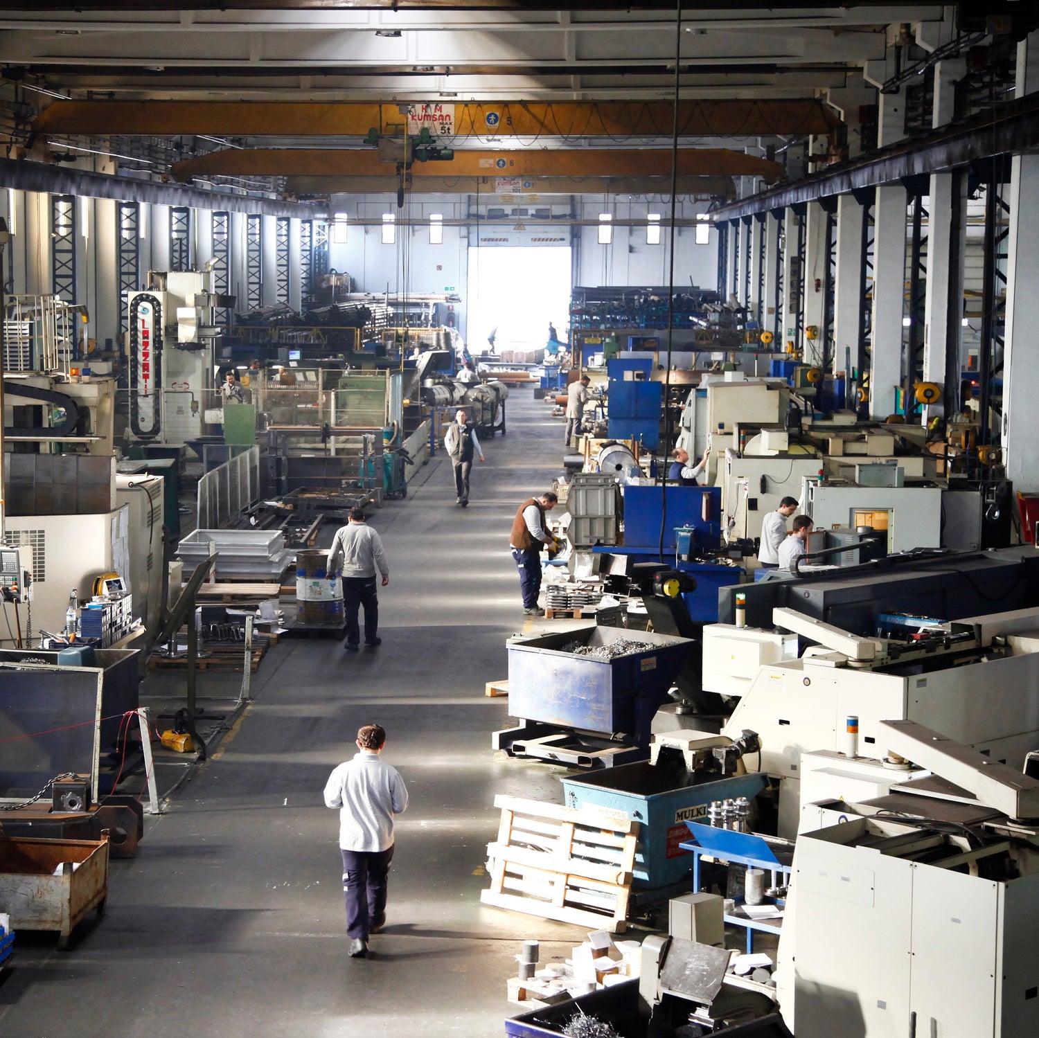 &lt;Looking down at a distribution area of a warehouse with several employees walking down a central aisle and others working at stations packing boxes for dispatch. Credit&gt; AdobeStock_250623771