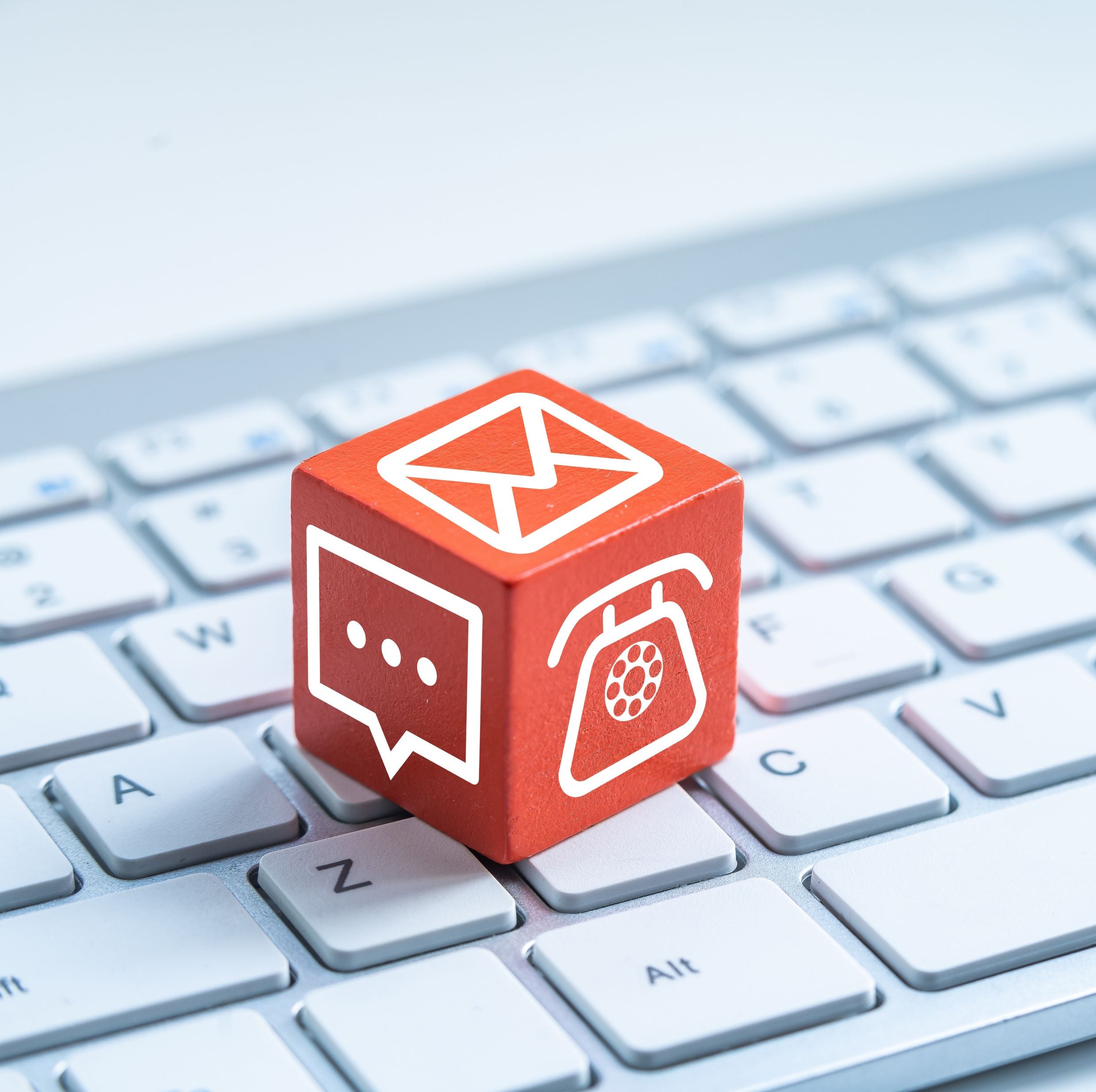 &lt;Red cube with emergency e-mail, letter, and phone symbols on the three visible faces, sitting on a white laptop keyboard. Credit&gt; AdobeStock_277649030