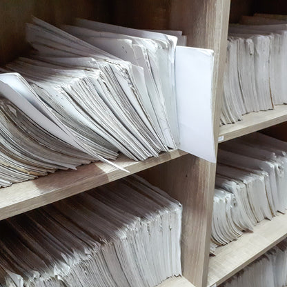 &lt;Two wooden shelf units full of paper GMP records stored in booklets. Credit&gt; AdobeStock_293074565