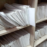 <White wooden shelves full of completed laboratory notebooks, records that must be maintained whilst the related product is marketed. Credit>  AdobeStock_293074565