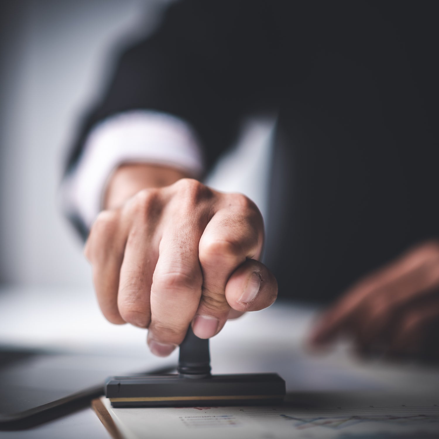 &lt;Man in suit making a disposition decision on a batch of materials with an ink stamp. Credit&gt; AdobeStock_295934749