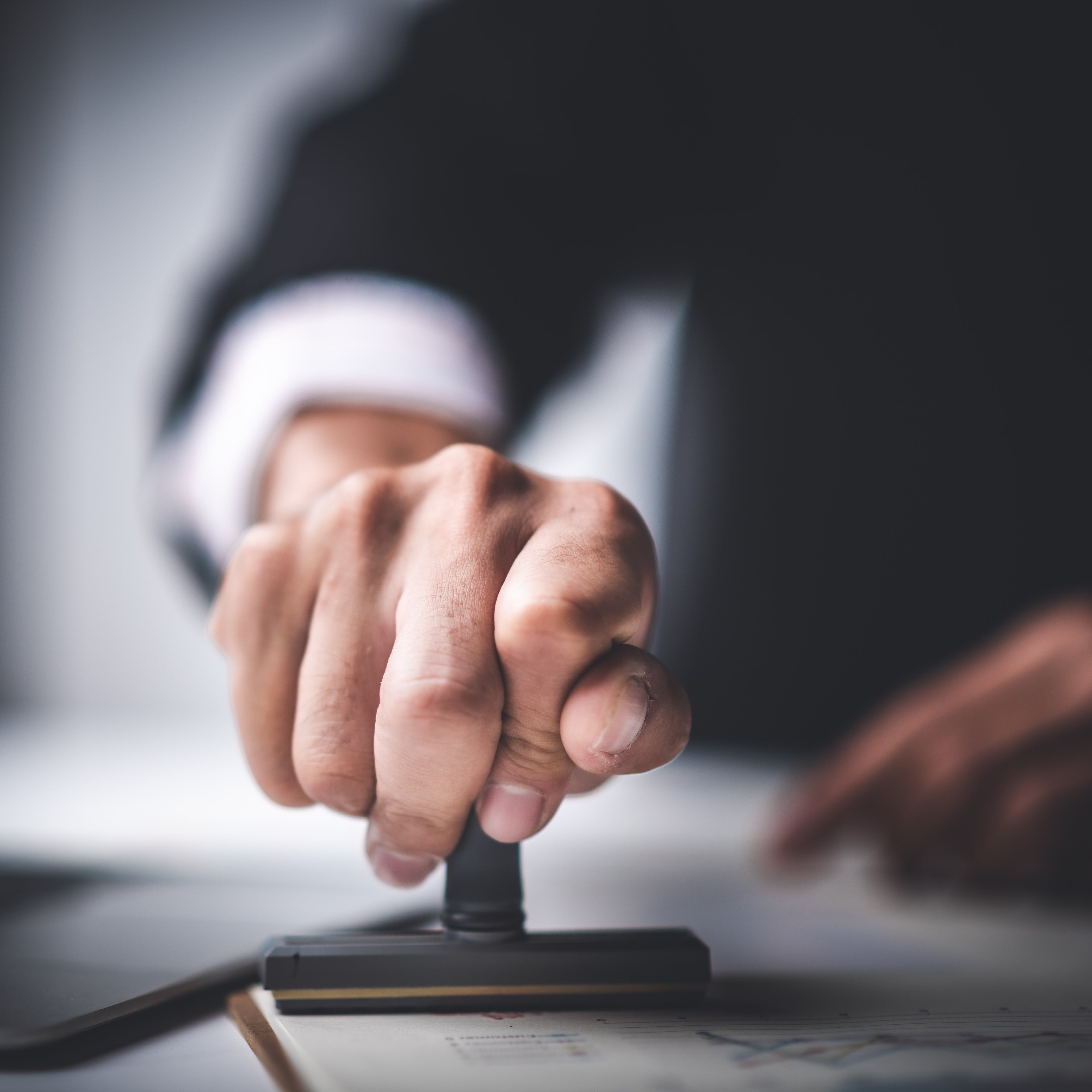 &lt;Man in suit making a disposition decision on a batch of materials with an ink stamp. Credit&gt; AdobeStock_295934749