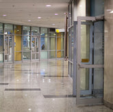 <Polished marble floor and wall lobby of the entrance to a drug facility via glass doors. Credit> AdobeStock_297383102