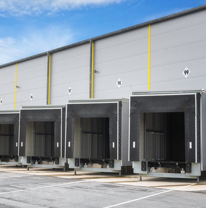 &lt;From the outside yard in sunshine a view of four roller shutter dock doors in the side of a warehouse for loading or unloading lorries, numbered 96 to 99. Credit&gt; AdobeStock_326508468