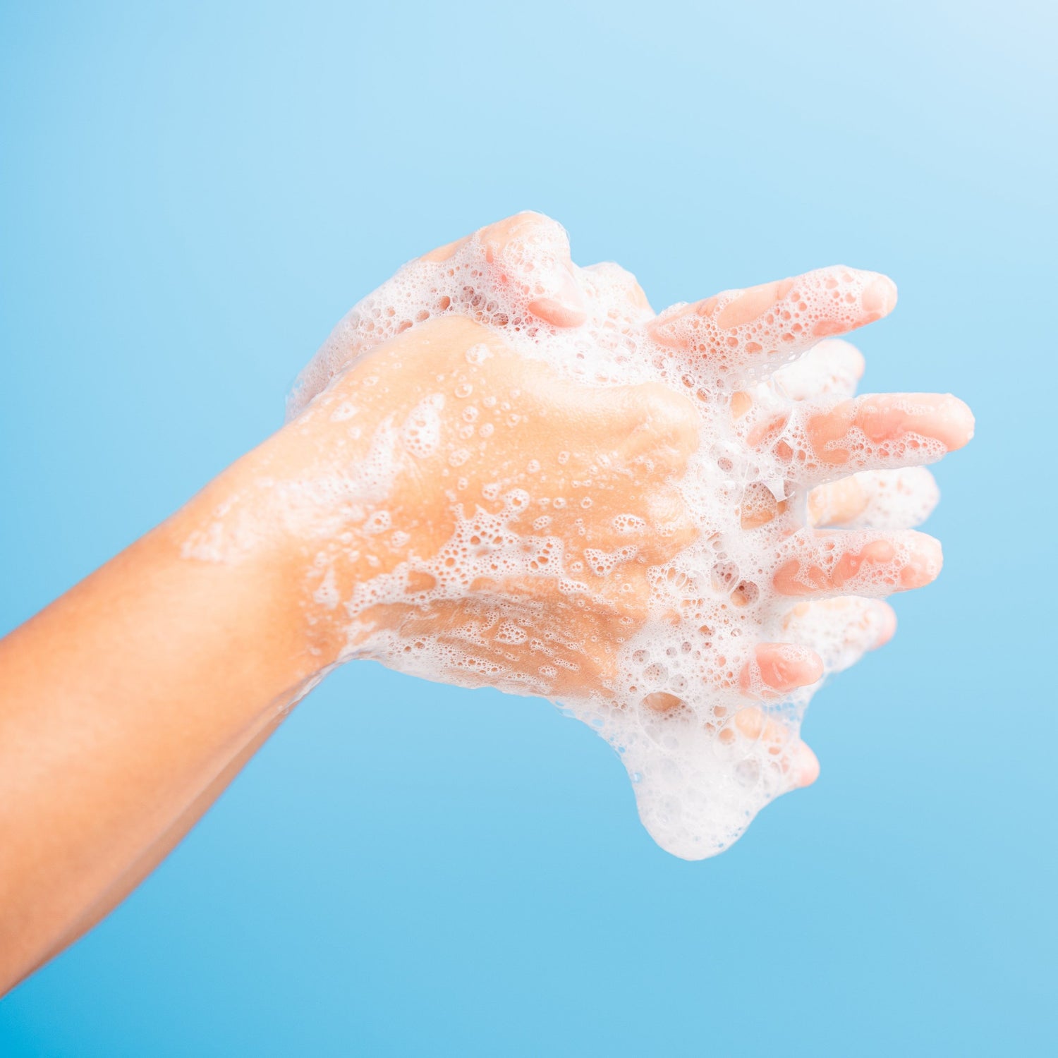 &lt;Picture of two arms against a light blue background creating foam lather as they rub and wash their hands together,. Credit&gt; AdobeStock_345027763