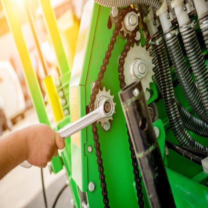 &lt;Arm of a Maintenance Engineer tightening the chain on the gears of a  green coloured filling machine with a socket spanner. Credit&gt; AdobeStock_362397816