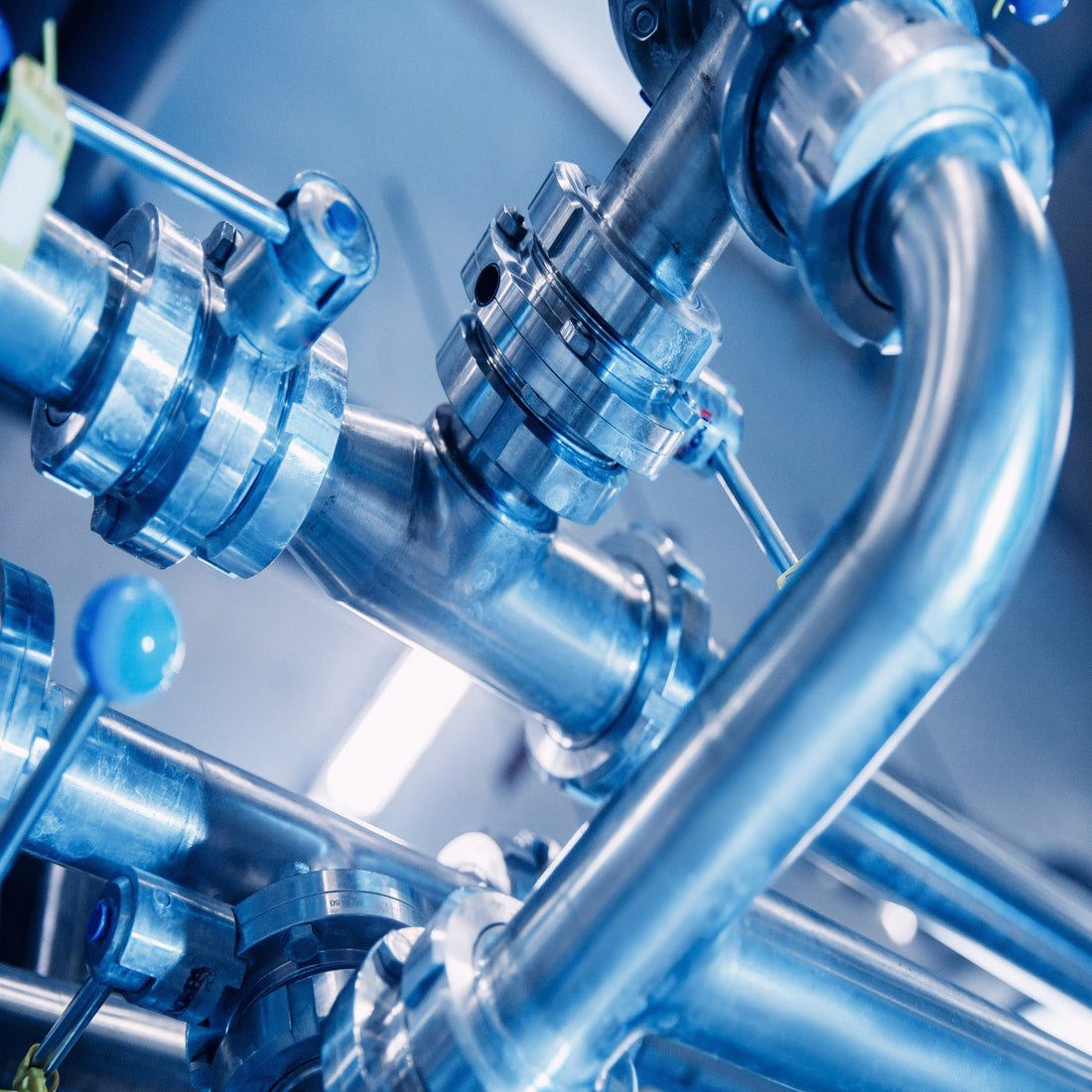 &lt;Arrangement of stainless steel pipework, connectors and valves in a blue lit dietary supplement manufacturing facility transporting water and waste to the correct location. Credit&gt; AdobeStock_388675579