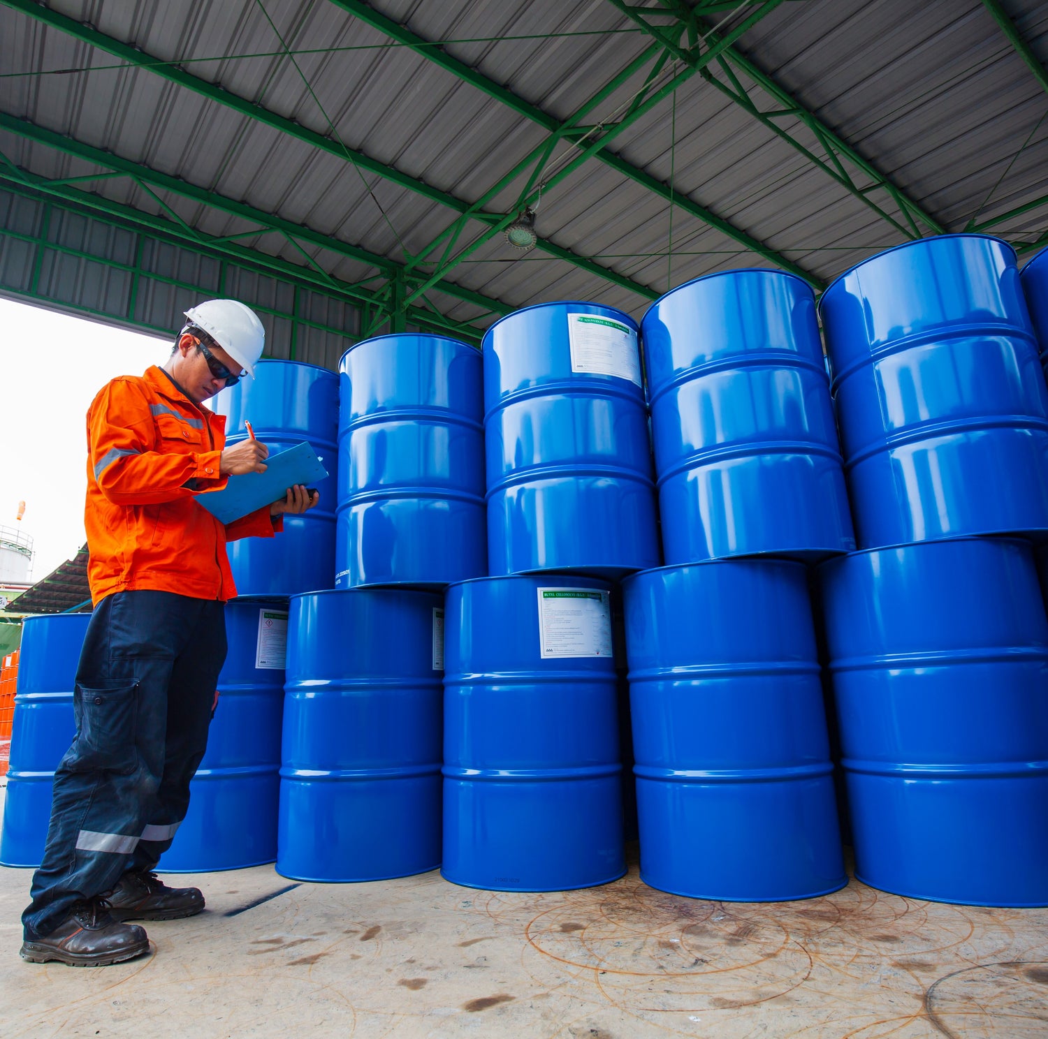 &lt;Male operator signing the collection note for over 10 empty blue metal drums awaiting disposal following use in manufacture of drug products. Credit&gt; AdobeStock_461729974