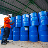 <Male operator signing the collection note for over 10 empty blue metal drums awaiting disposal following use in manufacture of drug products. Credit> AdobeStock_461729974