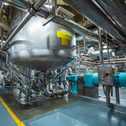 &lt;Raised, large stainless steel mixing tank with bottom mounted homogenizer and pipework in a manufcaturing area with light blue non-slip floor. Credit&gt; AdobeStock_467360310