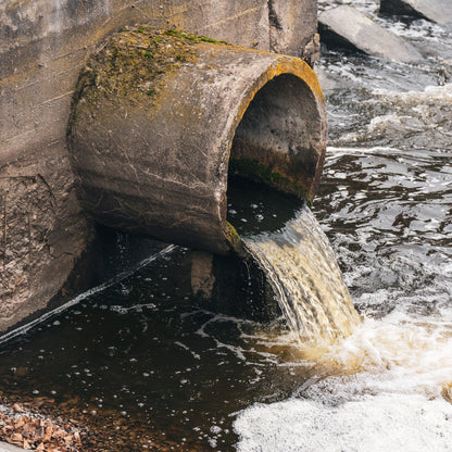 &lt;Old concrete pipe with green moss or lichen on top discharging some foaming waste water into a river as an example of not managing waste properly. Credit&gt; AdobeStock_472304078