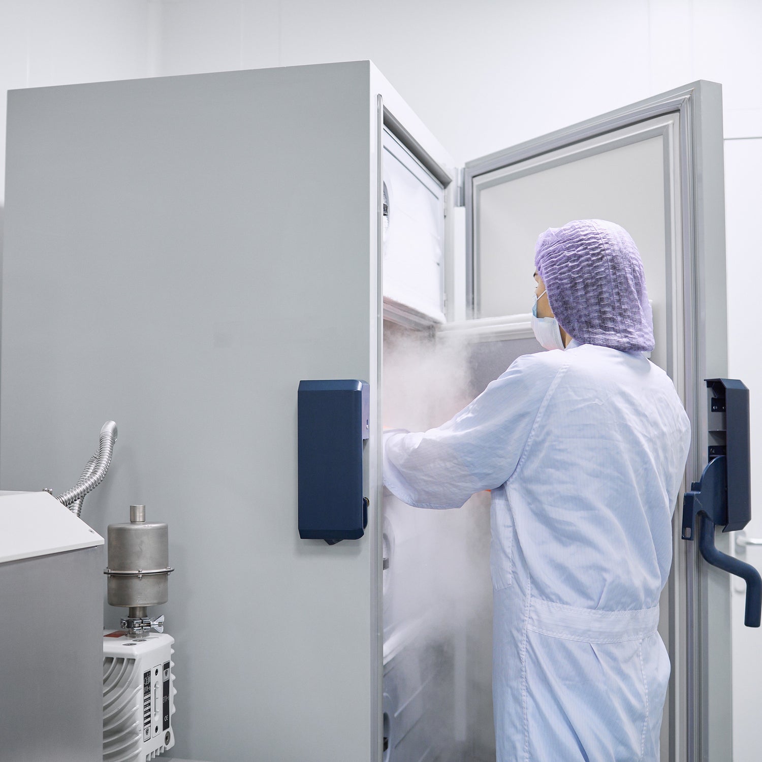 &lt;Stability analyst wearing lab coat and hairnet removing samples for testing from a single door temperature and humidity controlled stability chamber. Credit&gt; AdobeStock_500284461