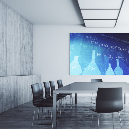 &lt;Laboratory meeting space with stone effect floor and wall, grey table, six dark grey chairs with chrome legs, and a large wall screen with blue background, light blue shapes of flasks, and chemical equations across it. Credit&gt; AdobeStock_694390582