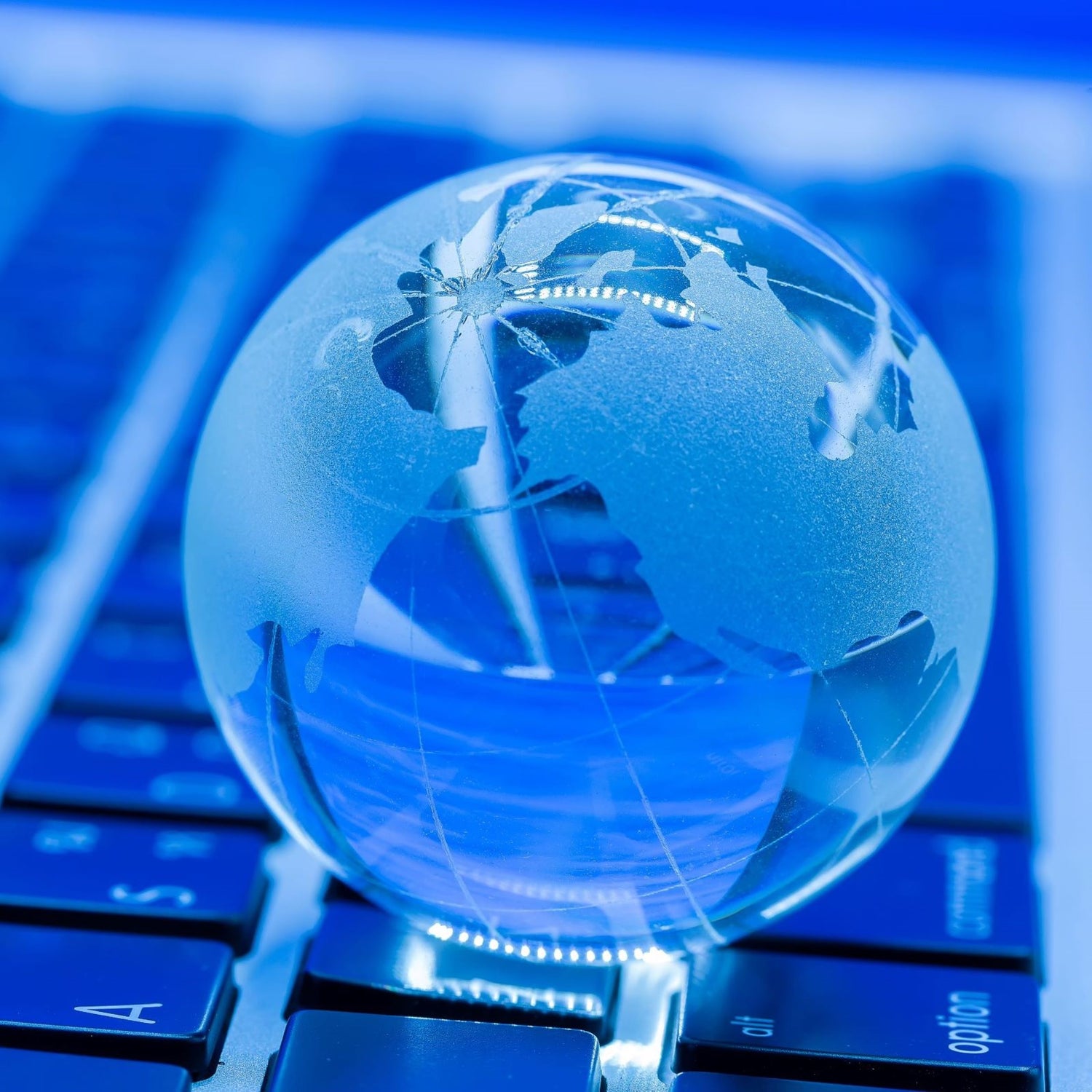 &lt;Clear and etched glass globe of the world sat on the blue keyboard of a laptop representing how global trade can be conducted online. Credit&gt; jcomp @ Freepik