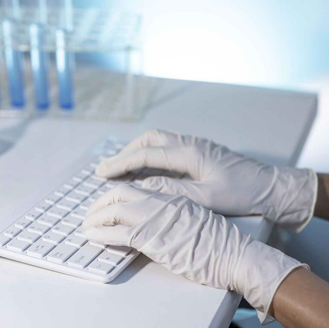 &lt;Laboratory analyst entering data electronically by white keyboard on the laboratory information management system LIMS next to a test tube rack with three blue tubes. Credit&gt; Freepik