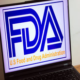 <Blue FDA logo and yellow wording US Food and Drug Administration on the screen of a black laptop to notify of a product recall event. Credit>  251413275 © Piotr Swat | Dreamstime.com