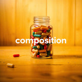 <Tall, open, clear glass jar full of yellow, green, and orange dietary supplement capsules, sitting on a wooden table with a wood panel wall behind it, and the word composition in front of it written in white. Credit> Freepik