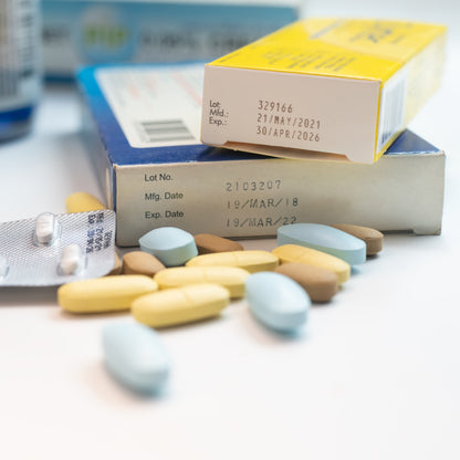 &lt;Expiration dates from stability studies on two cartons of different medicine products on a white table with some yellow, brown and blue oval tablets in front of them. Credit&gt; 2141323401 © Kasarp Studio | Shutterstock.com