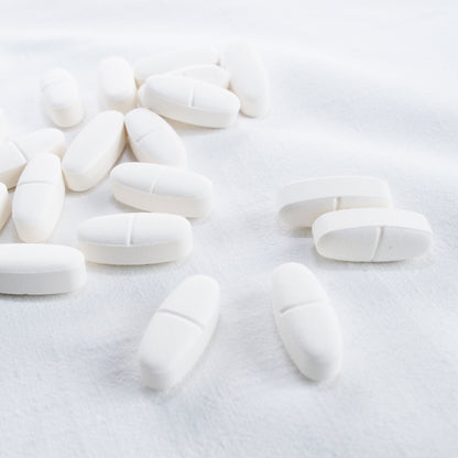 &lt;Oval white tablets with centre break line on a white linen cloth. Credit&gt; 1173911 by leagun @ freeimages